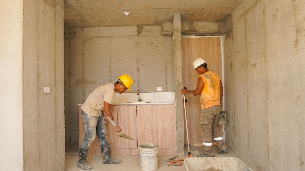 Personal de construcción trabajando en acabados de apartamentos